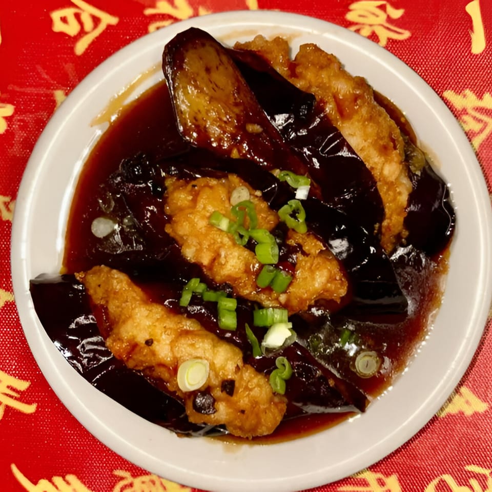 Red Lantern's fried eggplant and chicken in a dark sauce, garnished with green onions.